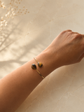 Zivèra handgemaakte tijgeroog dubbelsteen armband 18K goldplated aan pols met droogbloemen op beige achtergrond