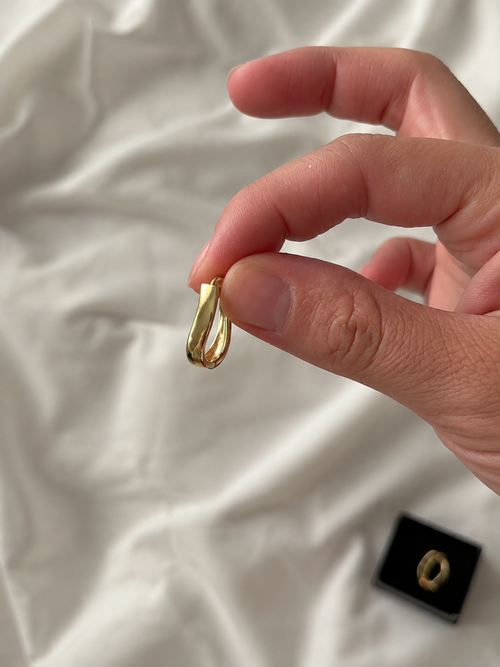 Zivèra Dubbele Gouden Huggie Oorbellen 14K Goldplated tussen vingers gehouden